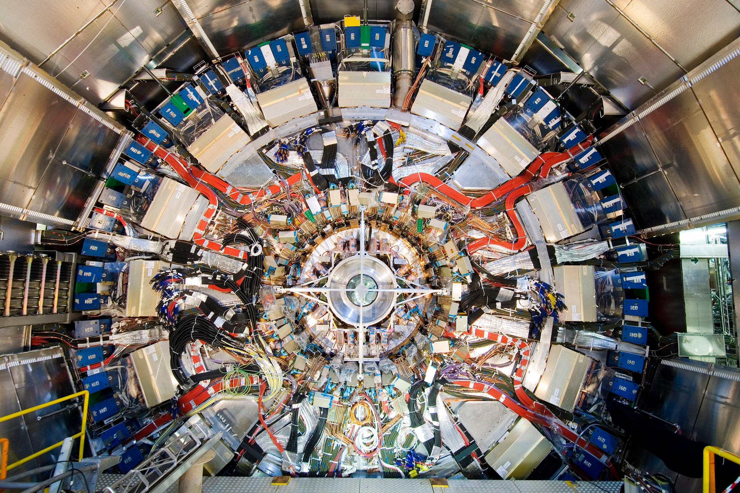 Inside a large scientific instrument with lots of shiny metal and cables